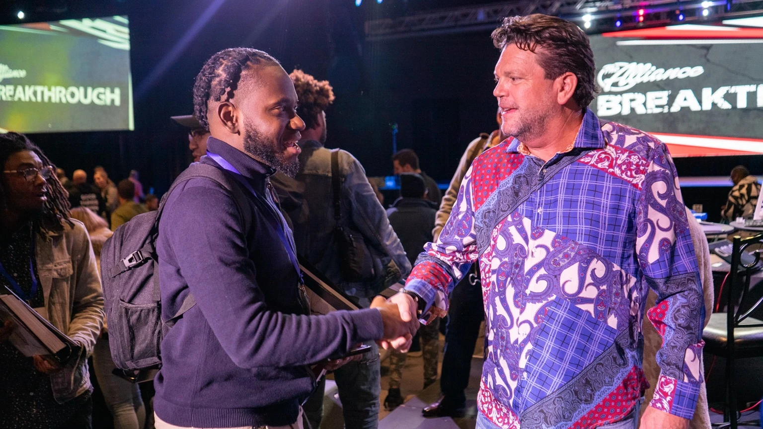 Two attendees greeting each other at a Breakthrough event