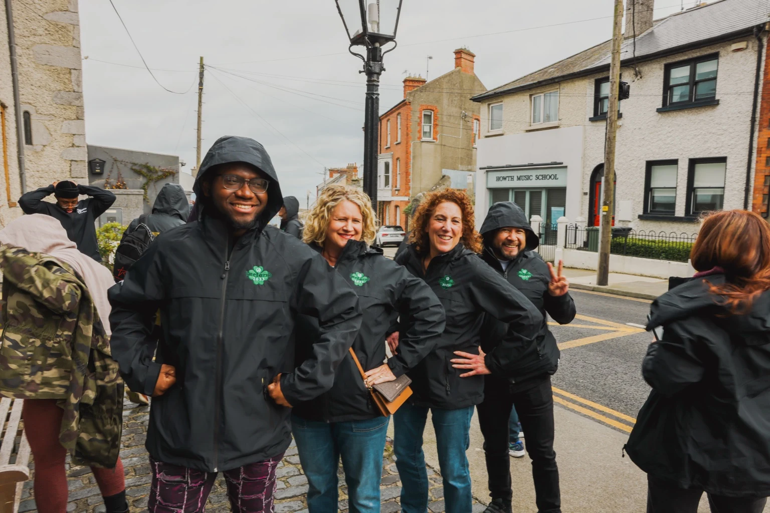 Three team members smiling on a town street